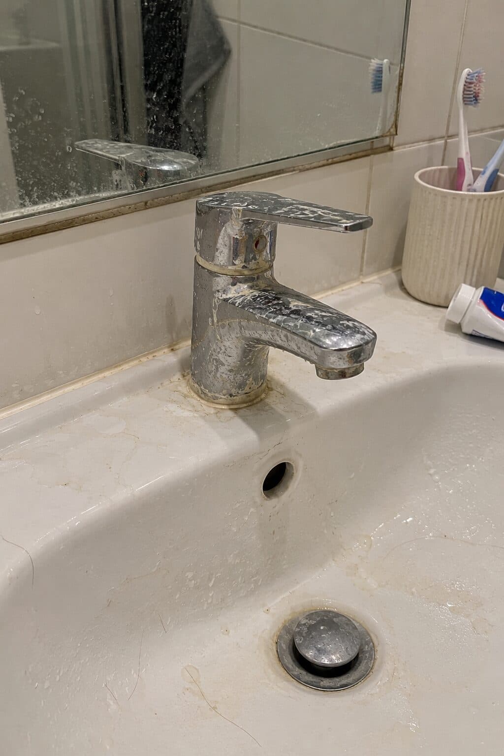 清潔前：洗手盆水龍頭積聚水垢及污漬